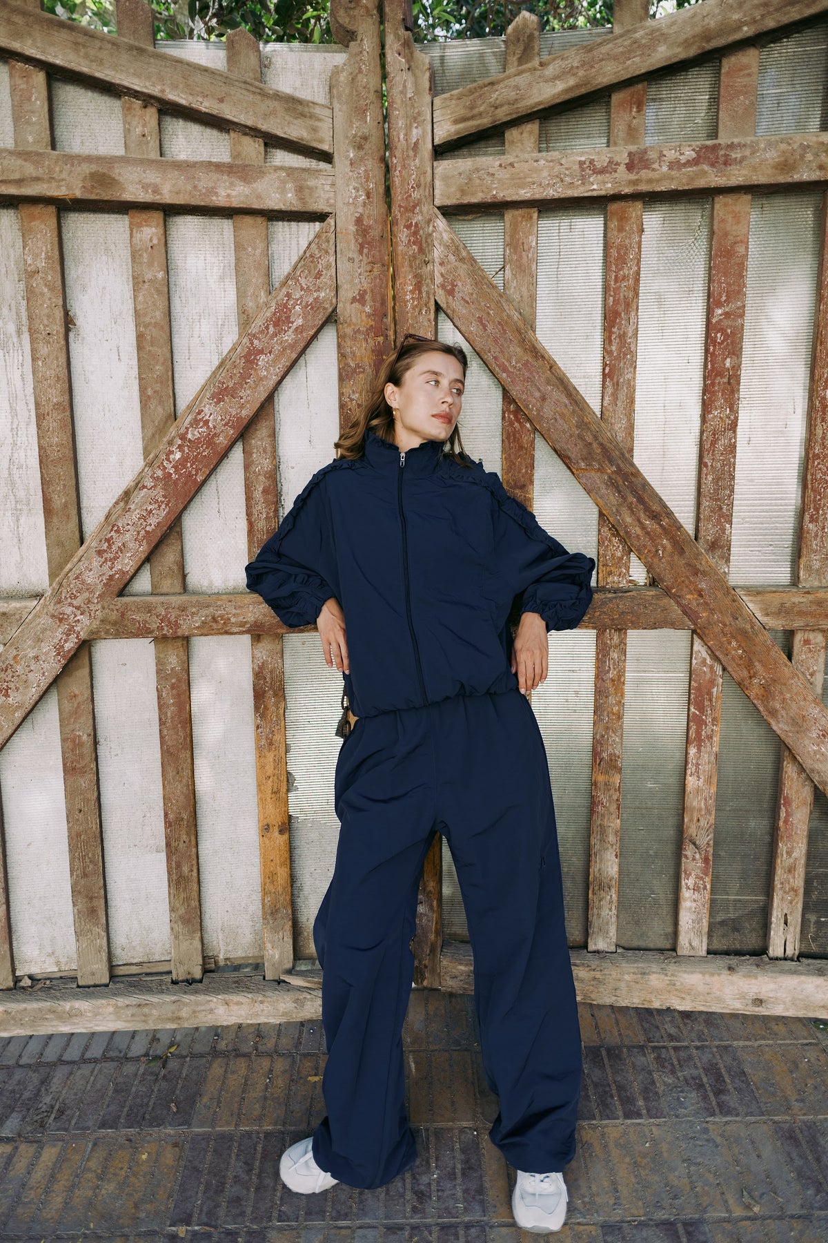 Navy track set, full length by a wooden gate