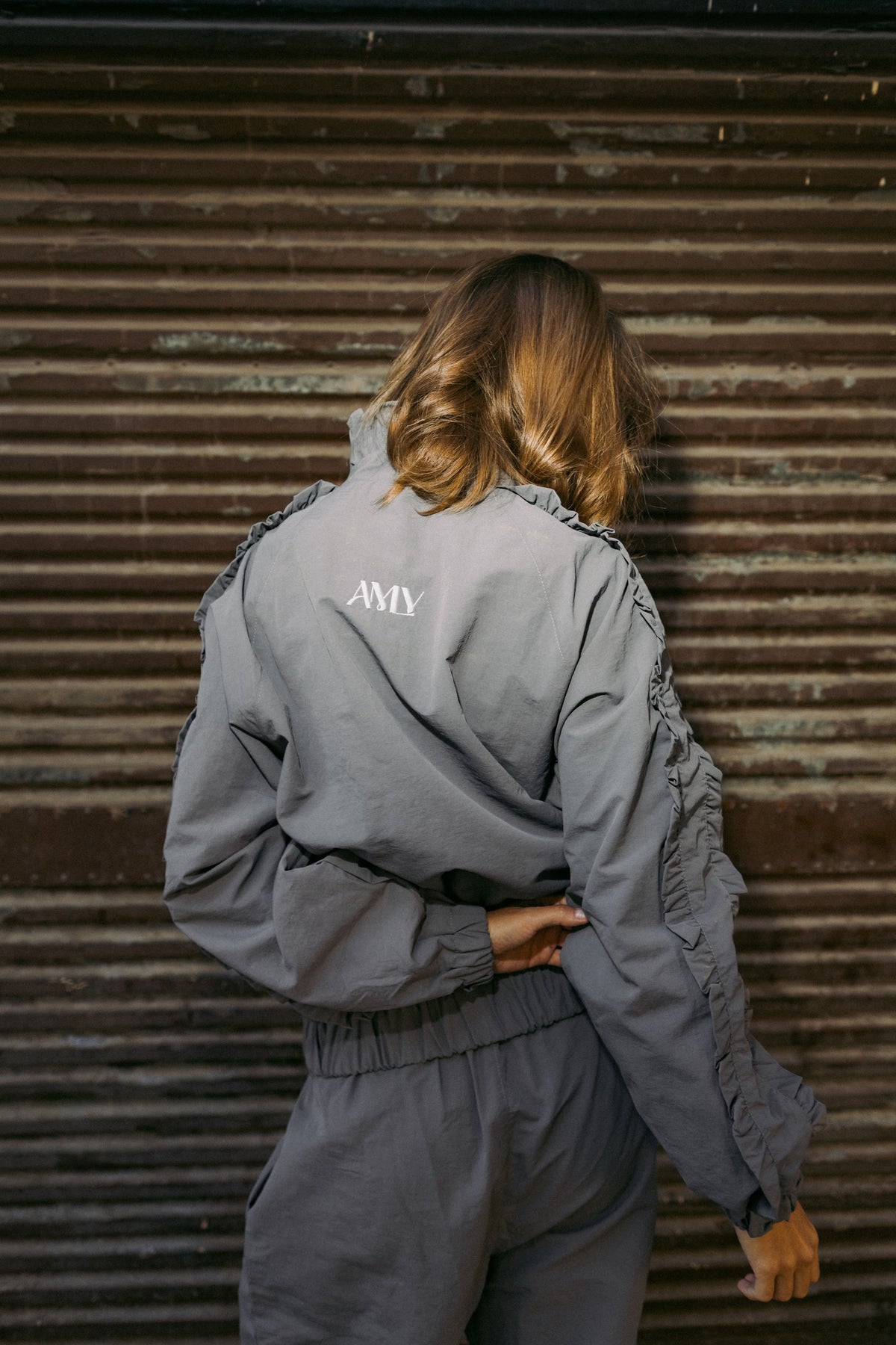 Slate grey jacket from the back with the AMLY logo